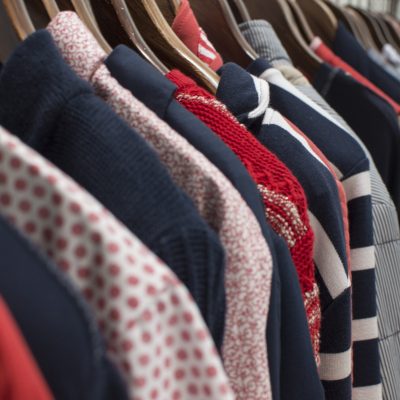a-row-of-red-and-navy-clothes-on-a-rail-in-a-store-F5BQSGE